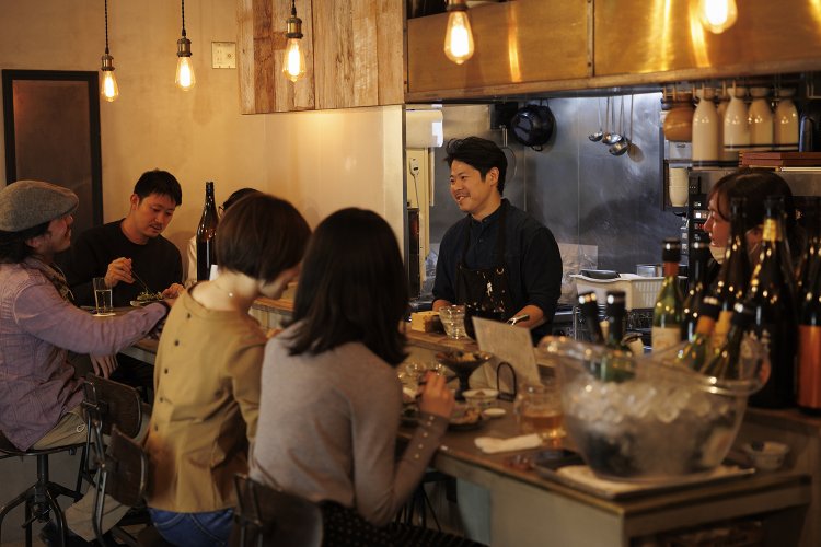 カウンター席とテーブル3卓。「夫は寝ても覚めても料理の話ばかり(笑)」と、ワインセレクト担当の杏梨さん（右）。