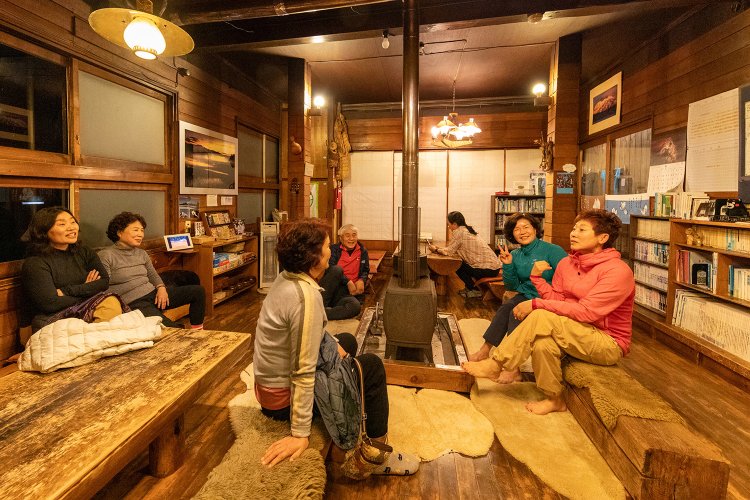 尾瀬の長蔵小屋、薪ストーブの談話室でひと息。淹れたてのコーヒーも楽しめる。（撮影＝白石ちえこ）