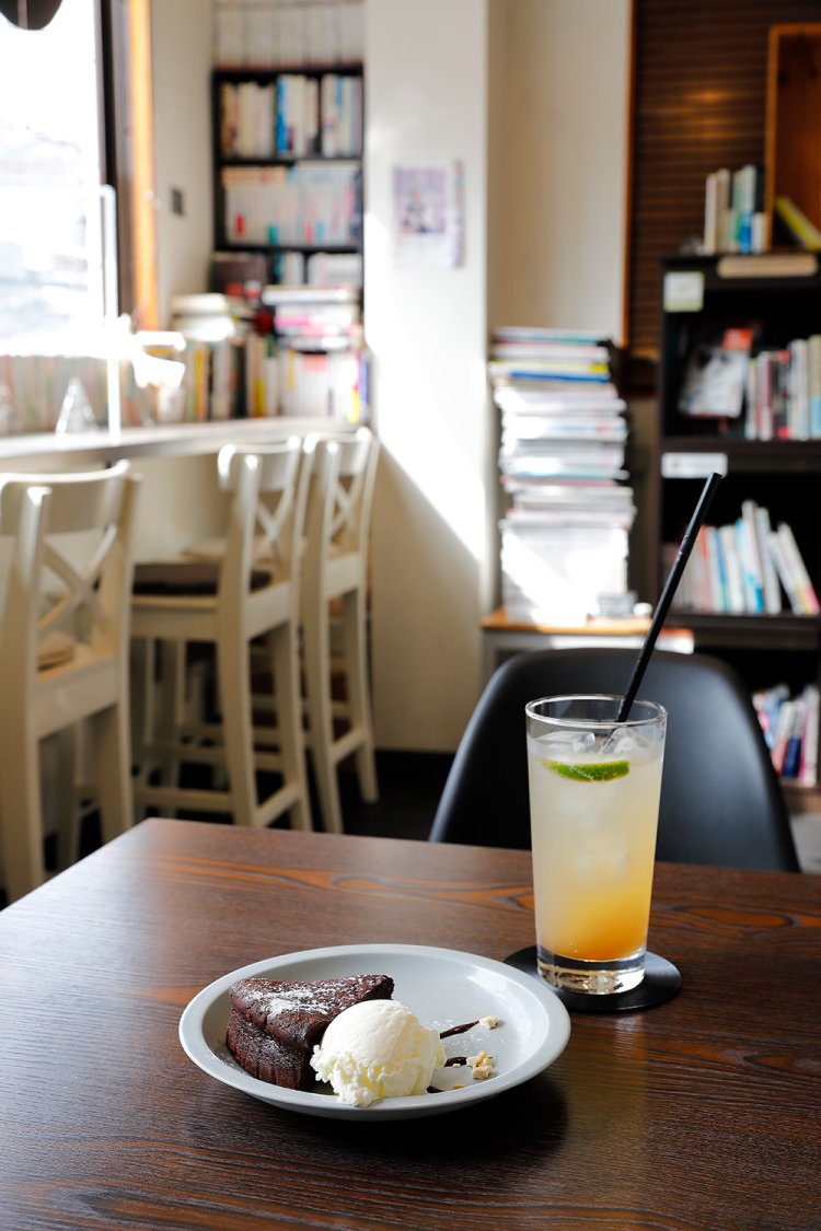 窓辺の本コーナー。温めて供される焼きチョコ・ジンジャー600円、自家製ジンジャーエール700円。