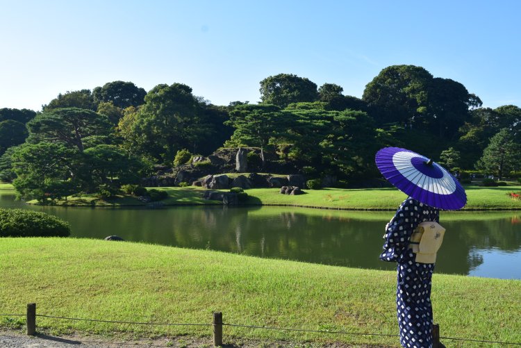 小高い築山と広い池がある文京区の『六義園』で池を背景に。