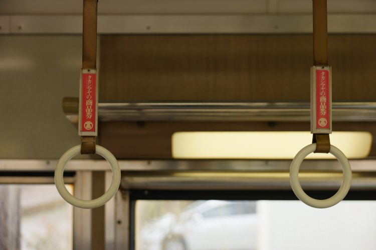 16000系と同様にクロスシートタイプの座席だが、こちらはシックな内装。各席に備わるように配置された窓も特徴的。吊り革には大阪・難波に店を構える髙島屋のプレートが残る。