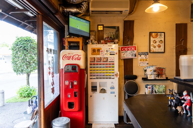 コカコーラの自販機に、ウルトラマンの人形など。店内は先代と現オーナーの趣味が混在。
