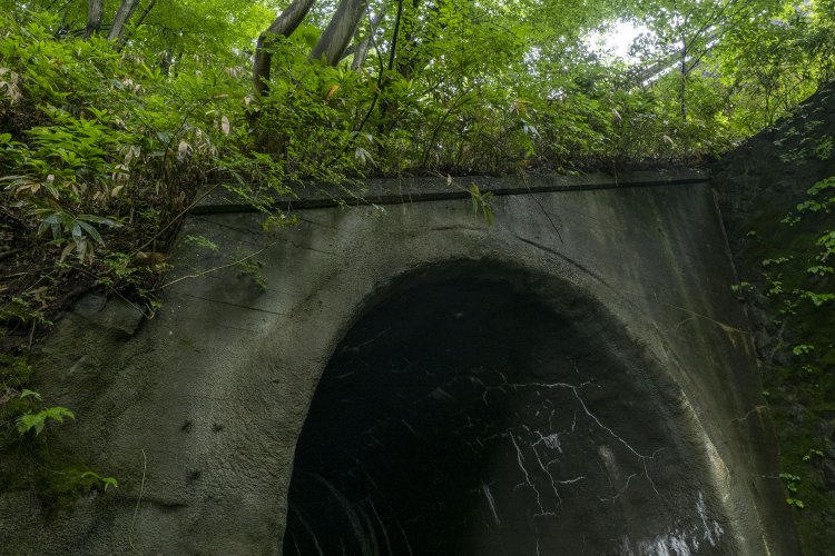 第一愛宕トンネルのポータル部分。左手前に3点の鋲（びょう）が見受けられるが、トンネル番号など何か掲示していたのかもしれない。