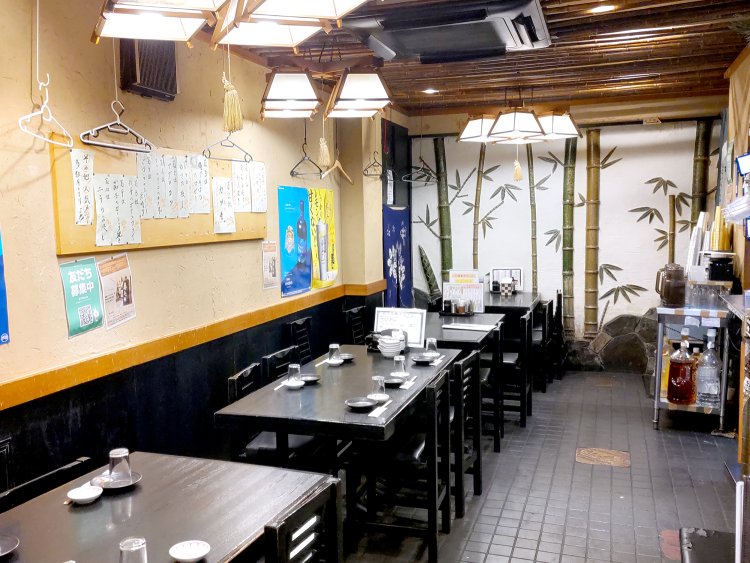 1階の奥にある和風のテーブル席。壁面のボードには、人気メニューのランキングが貼ってある。