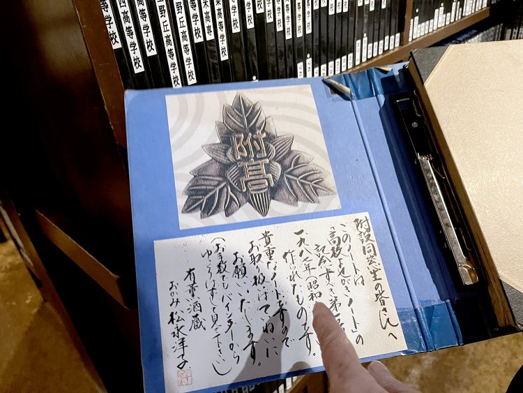 女将さんの手により校章や校歌などが貼り付けてある。ひとつずつ心を込めてノートを作っている。