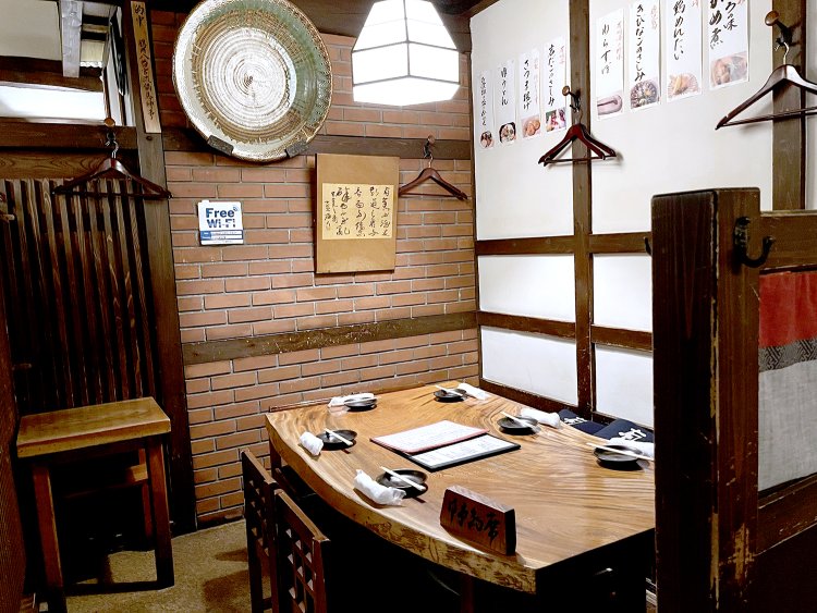 レンガの壁、一枚板のテーブルやランプなどに統一感があり落ち着いた雰囲気だ。