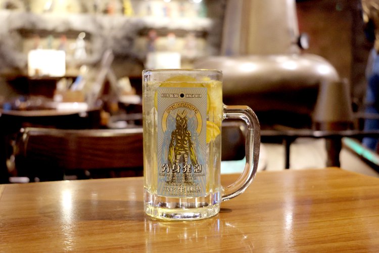 オリジナルのバルタン星人ジョッキで提供される「漬け込み果実ハイボール」。漬け込み果実はオレンジとレモンだ。