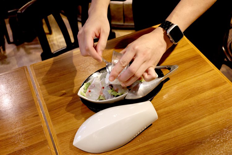 スタッフが白色破壊光線（大根とヨーグルトの特製ソース）をかけて完成！ 細かいところまで仕掛けがいっぱいだ。