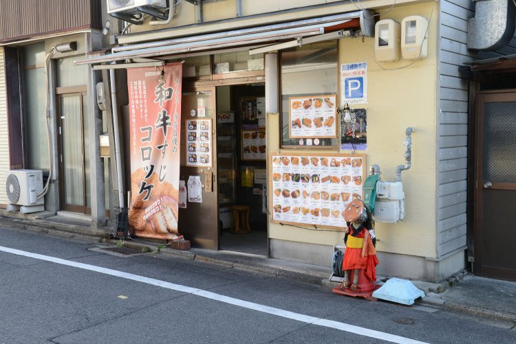 『山田フライ専門店』の店頭に立つ妖怪コロッケ。
