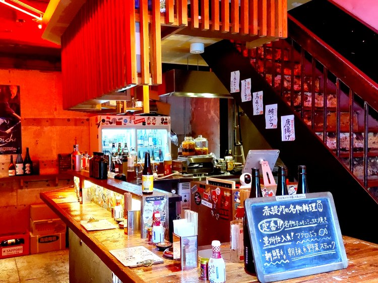 立ち飲み専用の1階はカウンター席のみ。赤いネオンの明かりがアダルトな雰囲気を演出。
