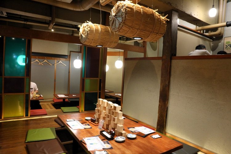 カラフルな色合いの座敷席。テーブルを照らすライトは、なんと俵！