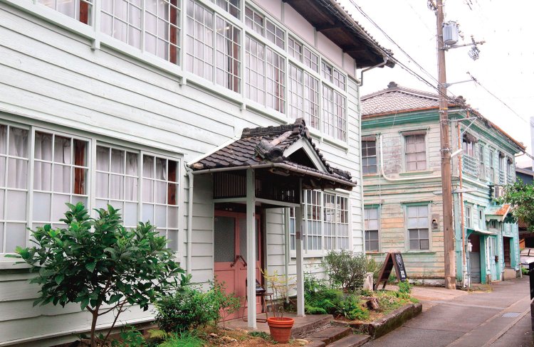 南側の登坂橋から撮影旧新宮郵便局を移築した丹鶴（たんかく）ダンス教室（奥）と、築80年余の建物を改修したセレクトショップ・288羽根学園。