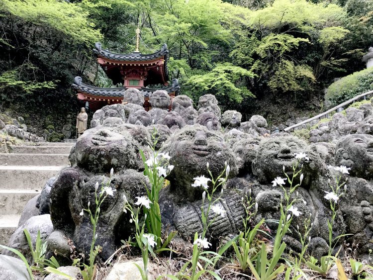 参拝者によって彫られた1200羅漢。奥は朱塗りの多宝塔。