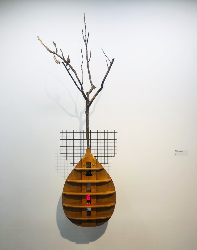 1998年に国連本部で展示された作品。柿の木は原子爆弾の形（ファットマン）にも見え、平和と戦争など、複数のイメージが重ねられている。宮島達男 『ブロンズで型取りされた被爆柿の木』 1998年。