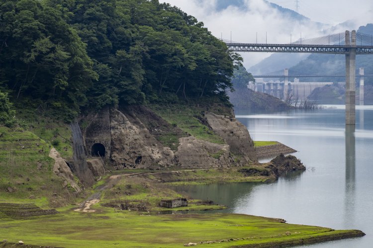 『八ッ場湖の駅丸岩』から旧線跡のトンネル群を望む。近寄って見ることは叶わないので、対岸からじっくりと見つめよう。奥は不動大橋と八ッ場ダムの堰堤である。