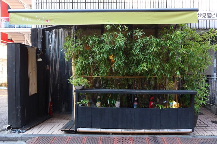 竹林のすきまに日本酒瓶が並ぶさわやかなたたずまいの店構えが目に涼しい。