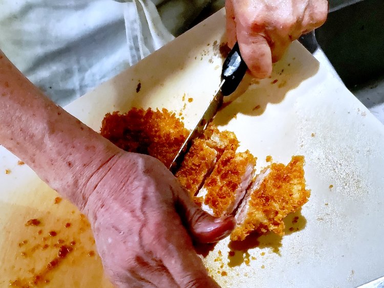 カツが揚がったら、食べやすいサイズにカット。カツを切る音から、衣のカラッとした感触が伝わってくる。