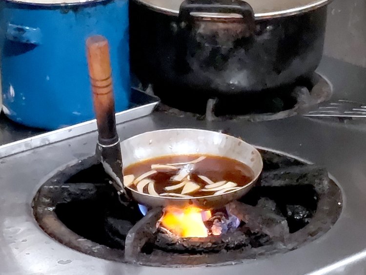 カツを揚げているあいだに、親子鍋にタレを用意。具材のタマネギを入れて加熱しておく。