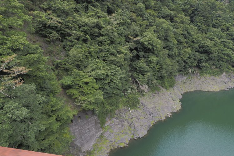 レインボーブリッジを渡るとき、斜面に旧線のコンクリート構造物が見えた。ここは小芦沢トンネルの明り取り箇所である。2024年8月16日撮影。