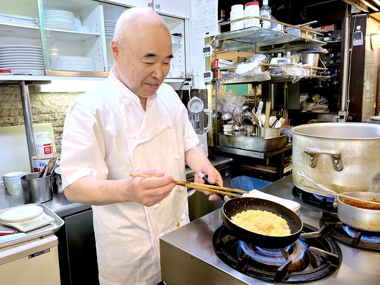 これをオムレツのように焼いていくのが難しい。調理するのは、和食、洋食なんでもござれ！ この店で10年以上勤務するコックのエンドウさんだ。