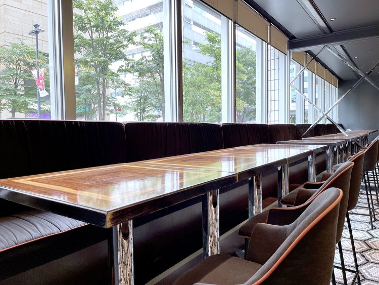 背の高いバーテーブルが並ぶカジュアルダイニングエリア。天井が高く、自然光がたっぷり入ってくる。