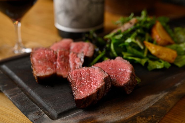 自家産牧草で育てる岩手・中屋敷牧場の牛肉の塊 炭火焼 100g 2200円～（写真は200g）。