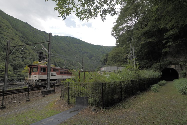 線路付け替え旧線と現在線との分岐箇所。右端はED90形の待避所。海野トンネルを出たあと旧線は左へ分岐し、この位置に川根市代駅のホームがあった。2024年8月16日撮影。