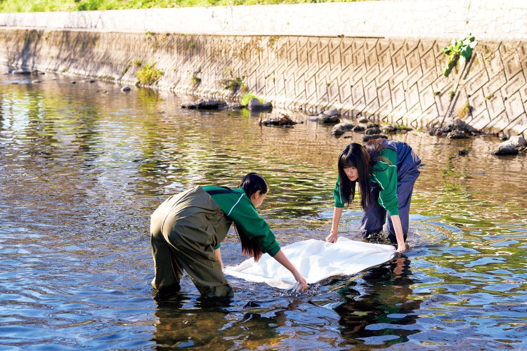 尾州ウールの仕上げに必要な「洗い」の作業場面を撮影した愛知県岩倉市の五条川。春には両岸の桜が色を添える。（C）2024 映画「BISHU 世界でいちばん優しい服」製作委員会。