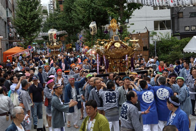 15基の町会神輿が都心のオフィス街をにぎやかに練り歩く。