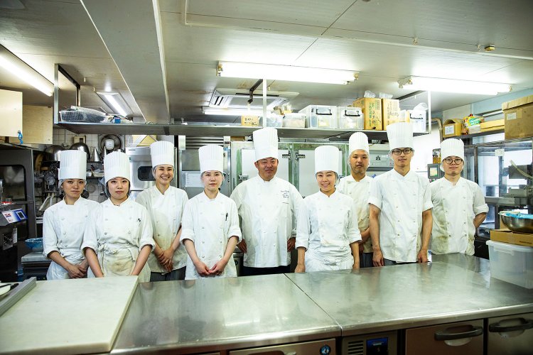 『成城アルプス』2代目の太田秀樹さん（中央）と若きパティシエたち。「新作も随時試作しています！」。