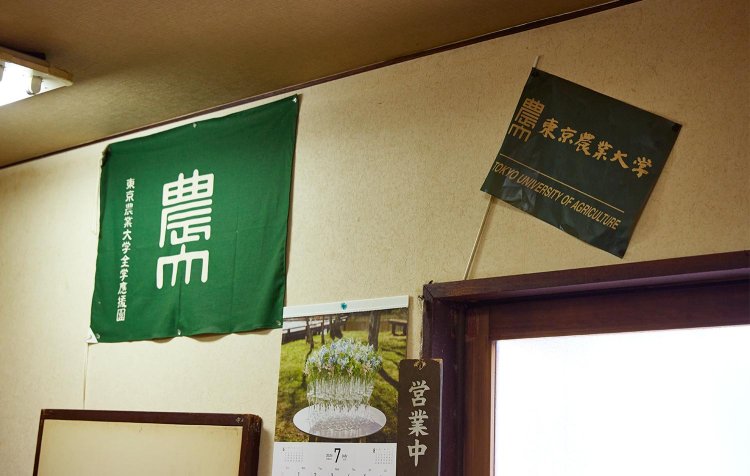 店内には農大の旗が。先輩に連れて来てもらって通うようになる学生が多いとか。