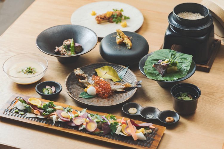 お食事処では、オープンキッチンで山海の食材を炭火で炙る夕食が好評。朝食は半ビュッフェ形式の和食御膳を味わえる（写真提供＝shuhei tonami）。