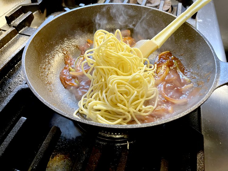 炒めた具材をケチャップで味付け、茹でて一晩寝かせたスパゲティを投入。よく絡めて味をなじませる。