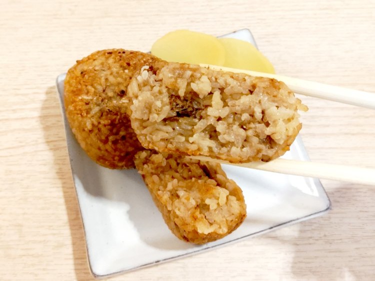 おにぎりを割ってみると、中まで醤油が染みている上、かつお節が混ぜ込んであるのがわかる。