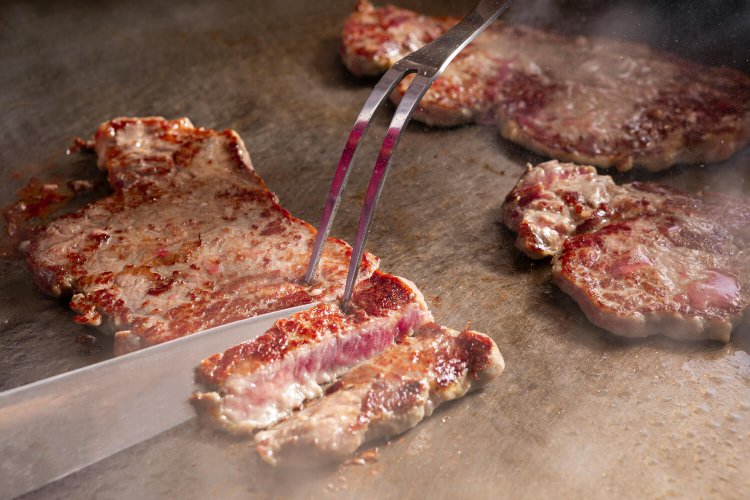 焼きたてを切り分けてくれる鉄板焼は大人気（写真提供＝亀の井ホテル）。