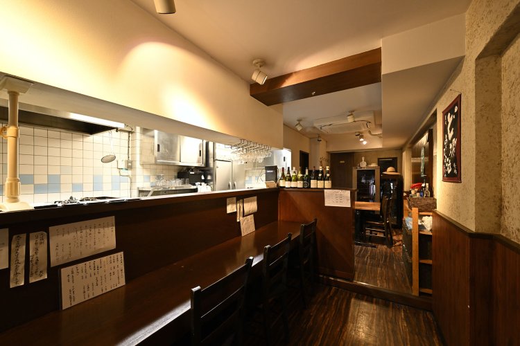 カウンター席もあるので一人飲みでも気軽に利用できる。カウンター横の書棚にはそばや酒に関する本も並ぶ。