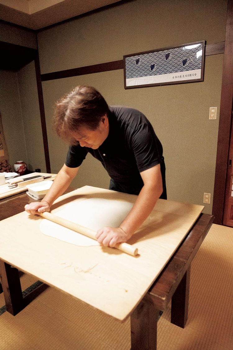麺棒で均一になるようそばをのす悠二さん。そば粉は北海道か ら取り寄せる。