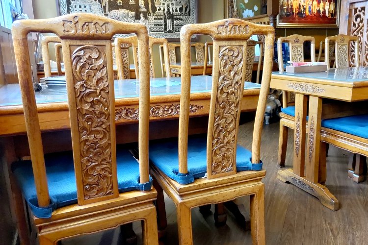 イスもテーブルもすべて手彫り。背もたれの上部に店名が彫られているのがわかる。