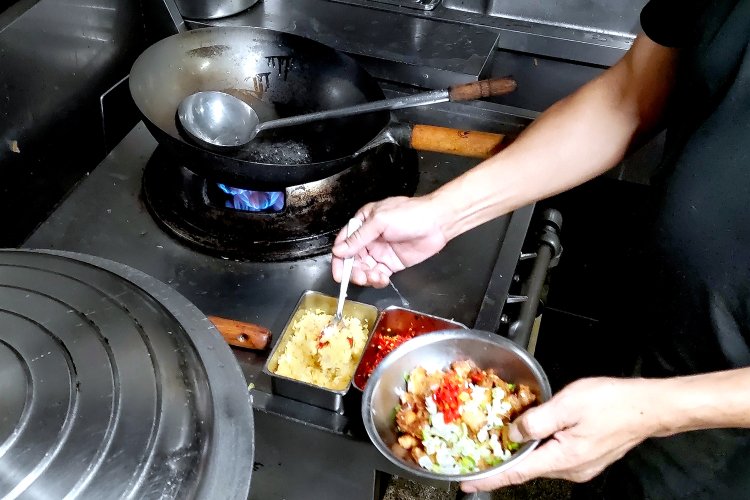 豚肉が入ったボウルに、具材のネギのほか、唐辛子、ニンニク、ナンプラーといった調味料を加える。