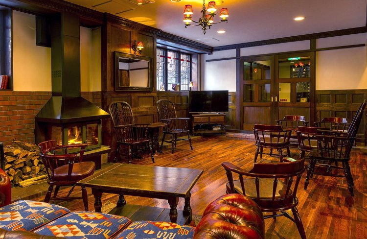 薪ストーブのあるラウンジ。山岳図書や上高地のビデオも置いている。