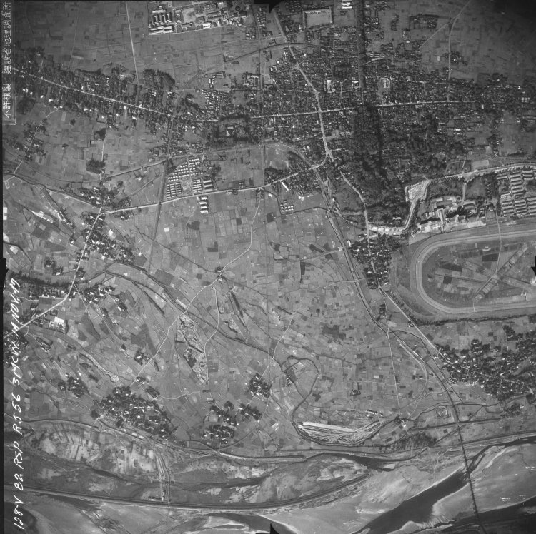 戦後の米軍撮影航空写真から。写真中心部分を見ると、真っ直ぐの線路が「J」字となり、途中で競馬場側へ分岐する線路が分かる。[八王子　番号：USA コース：R556-No1-128 1947/11/14撮影　米軍https://mapps.gsi.go.jp/maplibSearch.do?specificationId=219047]。