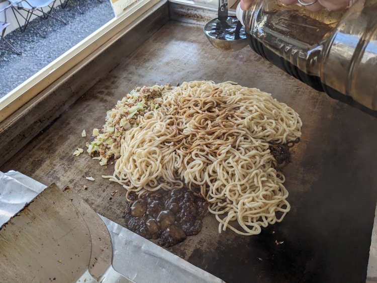 熱した鉄板の上で麺と具材を混ぜ合わせ、自家ブレンドのソースを絡めていく。