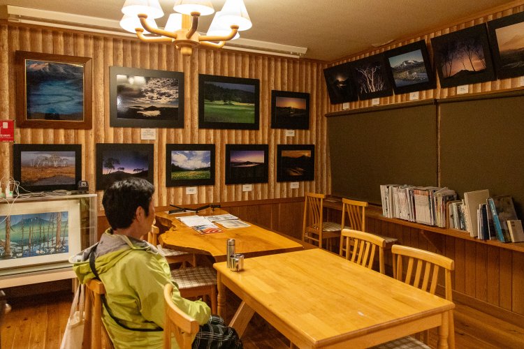 洋風談話室には山の写真が飾られ、山関連の本も置かれている。