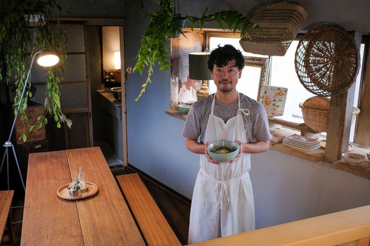 店主の佐藤恭平さん。持っているのはフォーMサイズ980円。