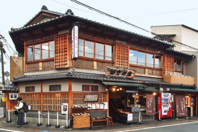 伏見稲荷大社裏参道の鳥居前に佇む。店頭で焼くウズラも人気。