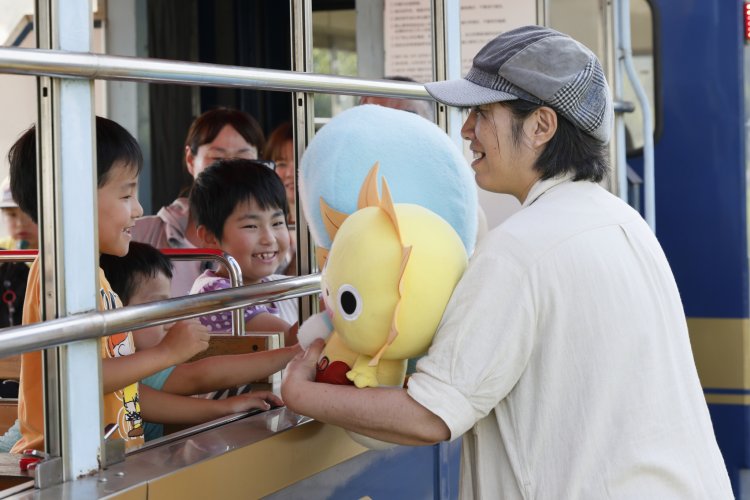列車を出迎える阿蘇白川駅のキザキさん（上）と、中松駅の高嶋さん。