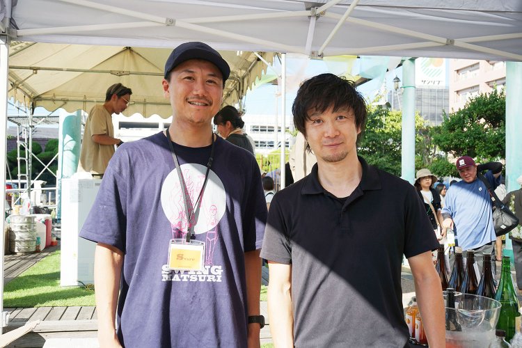 「スイング祭り」にも出展しお酒を販売していた許山さんと、15年以上『ノミヤマ酒販』を支えている大田黒雅人さん（右）。