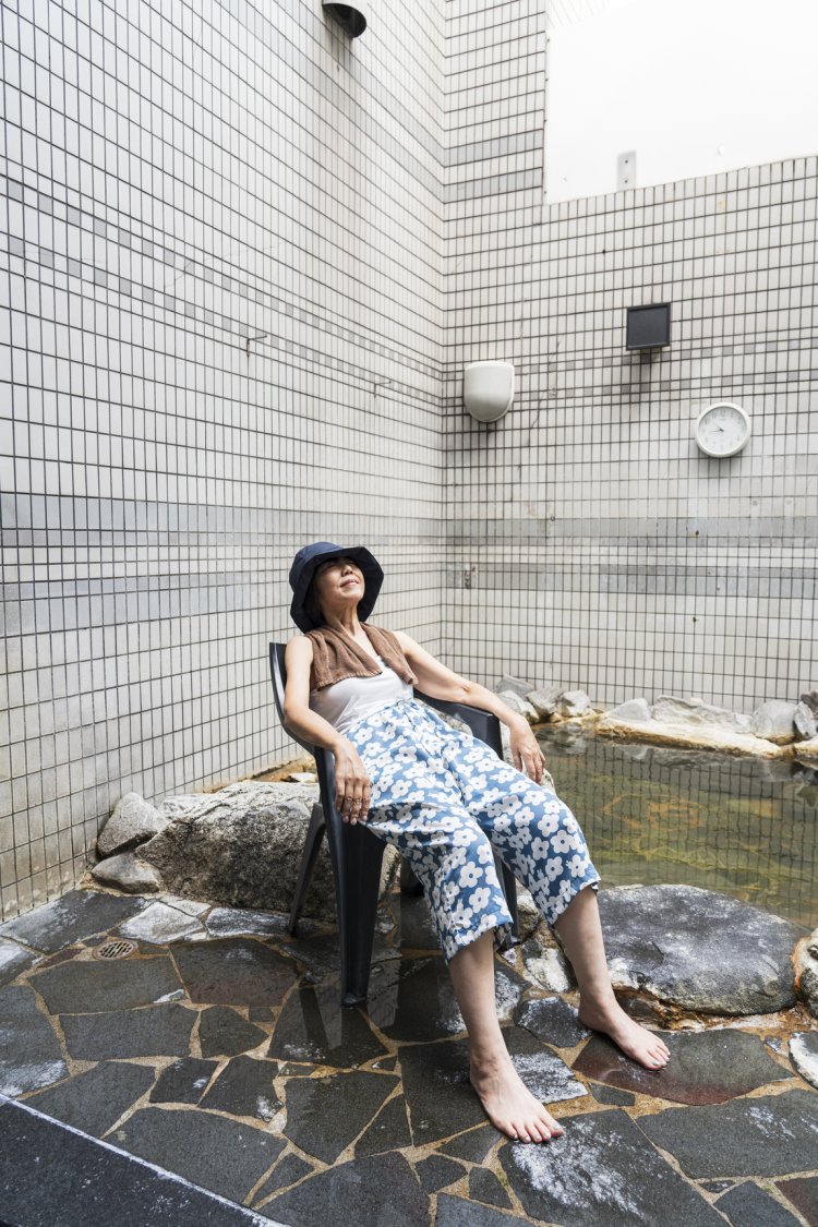 吹き抜けの外気浴スペース。見上げると熊本の空、奥は露天風呂。