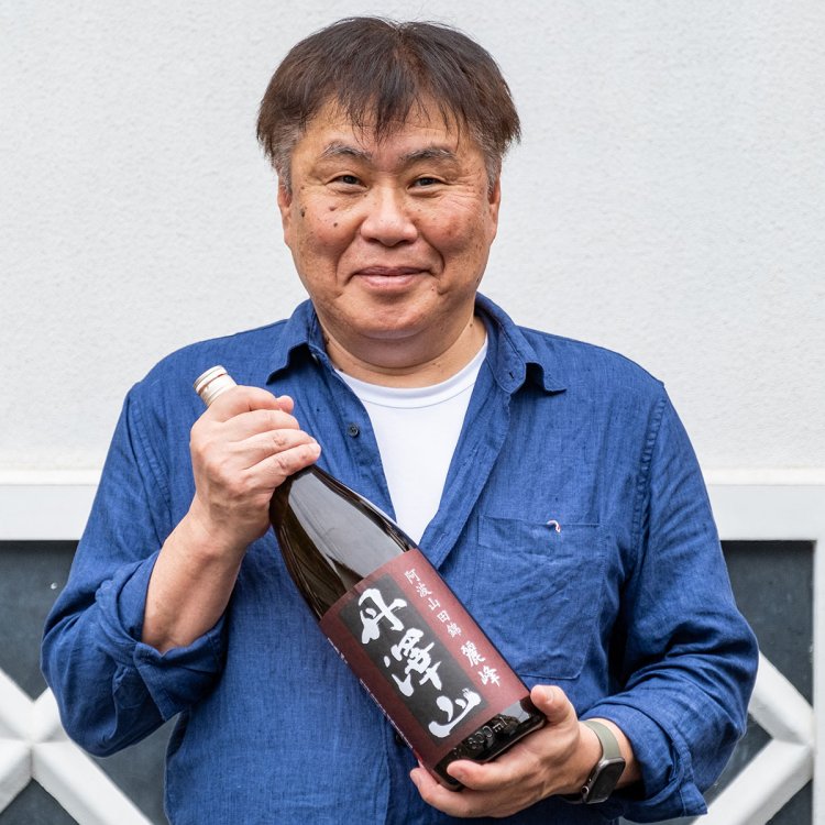 「丹澤山麗峰」1.8ℓ3850円を手に燗酒への思いを語る露木さん。