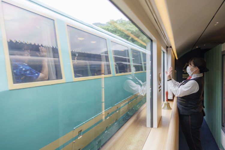 ゆふ高原線は全線単線。「ゆふいんの森」3号と列車交換のため、由布院駅に6分停車。乗客と窓越しの出会いが。